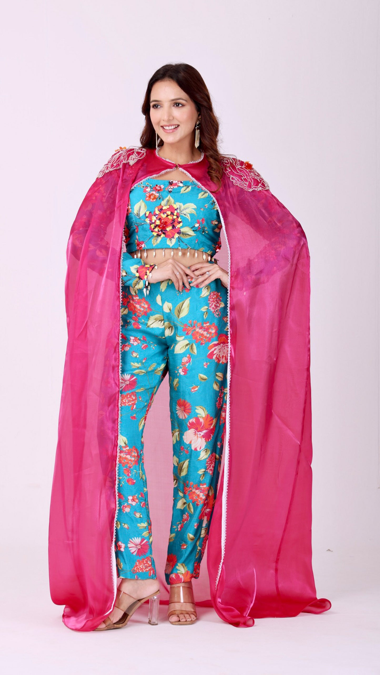 Floral embroidered turquoise co-ord set paired with a statement pink cape