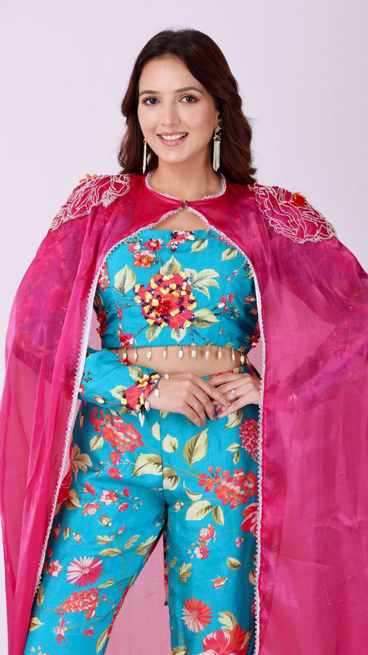 Floral embroidered turquoise co-ord set paired with a statement pink cape