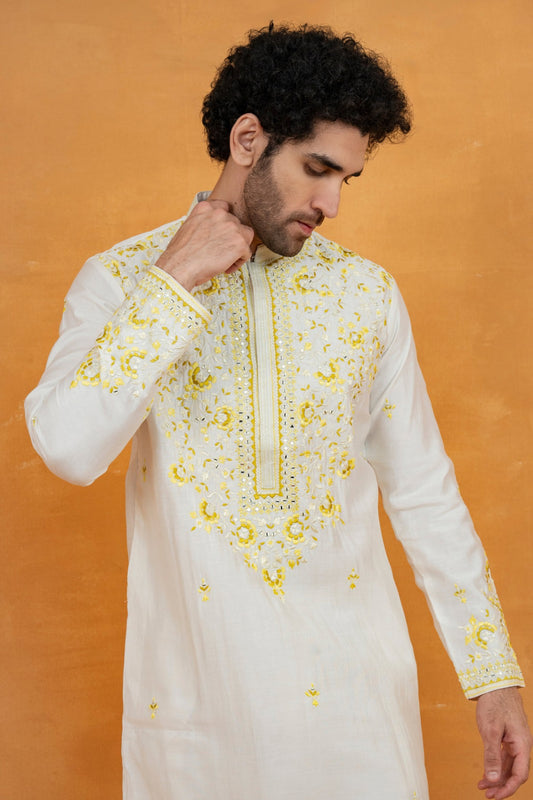 Cream silk kurta set with yellow resham embroidery and mirror work