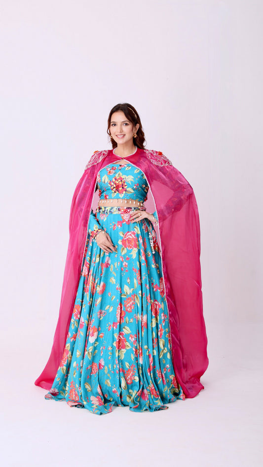 Turquoise vibrant floral lehenga choli set paired with a embroidered cape