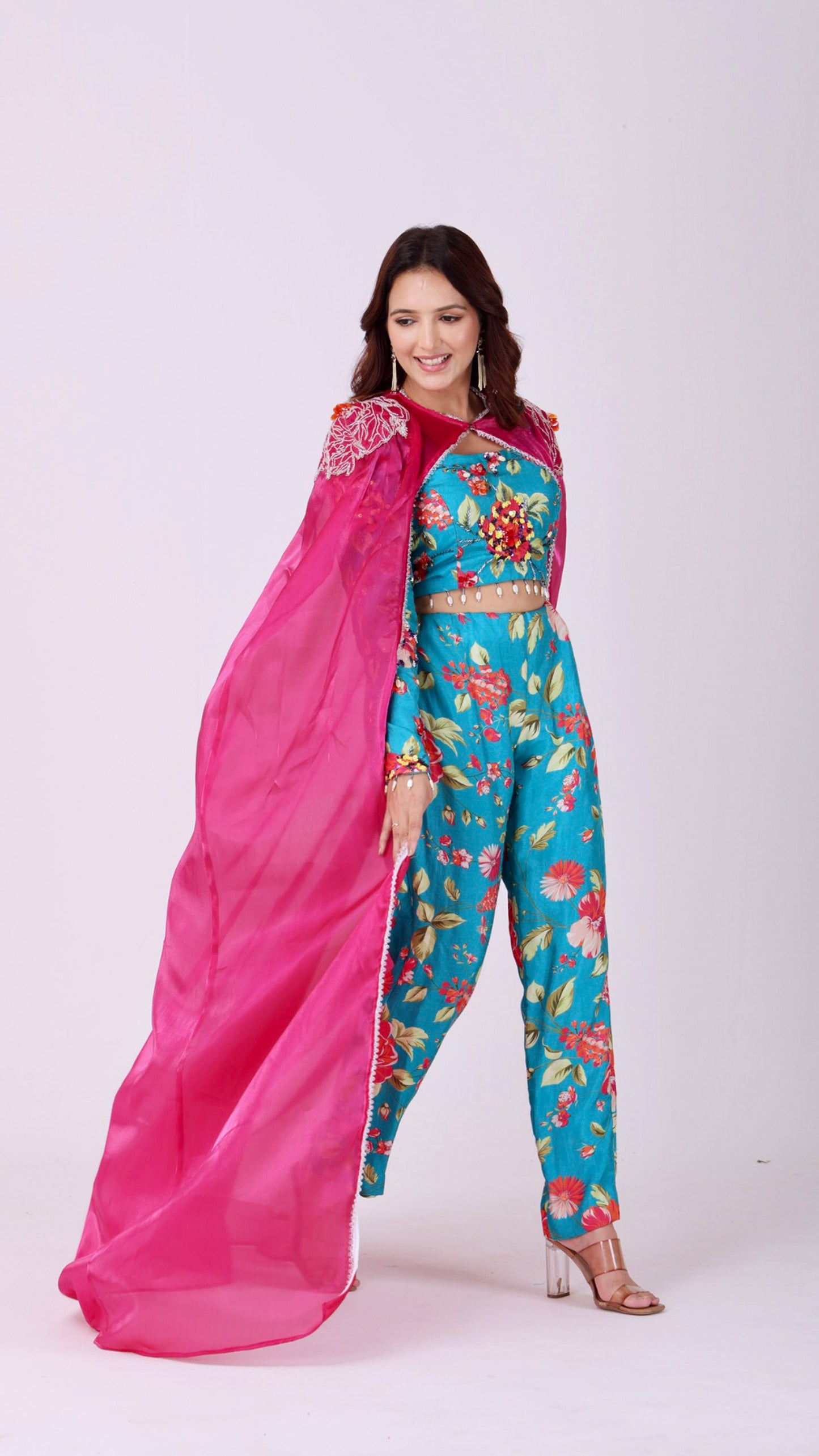 Floral embroidered turquoise co-ord set paired with a statement pink cape