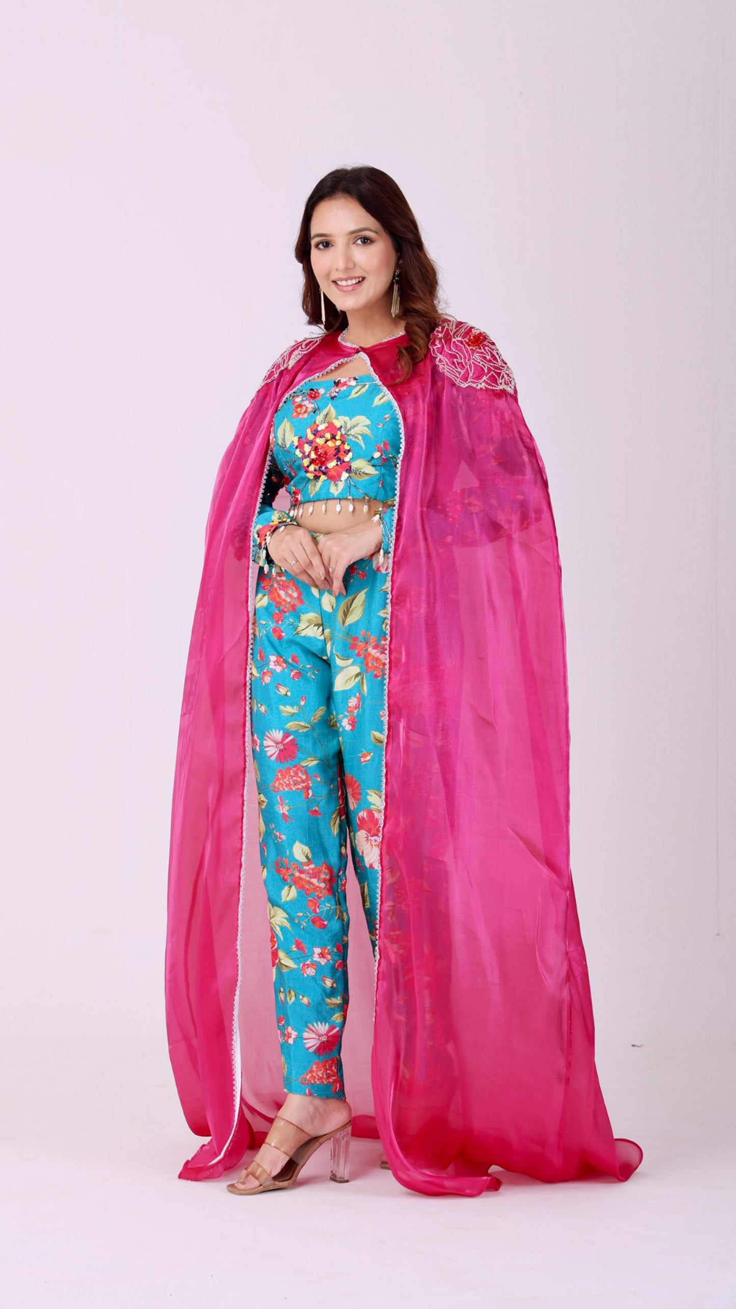 Floral embroidered turquoise co-ord set paired with a statement pink cape
